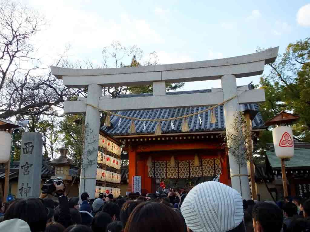 a gray torii and many visitors