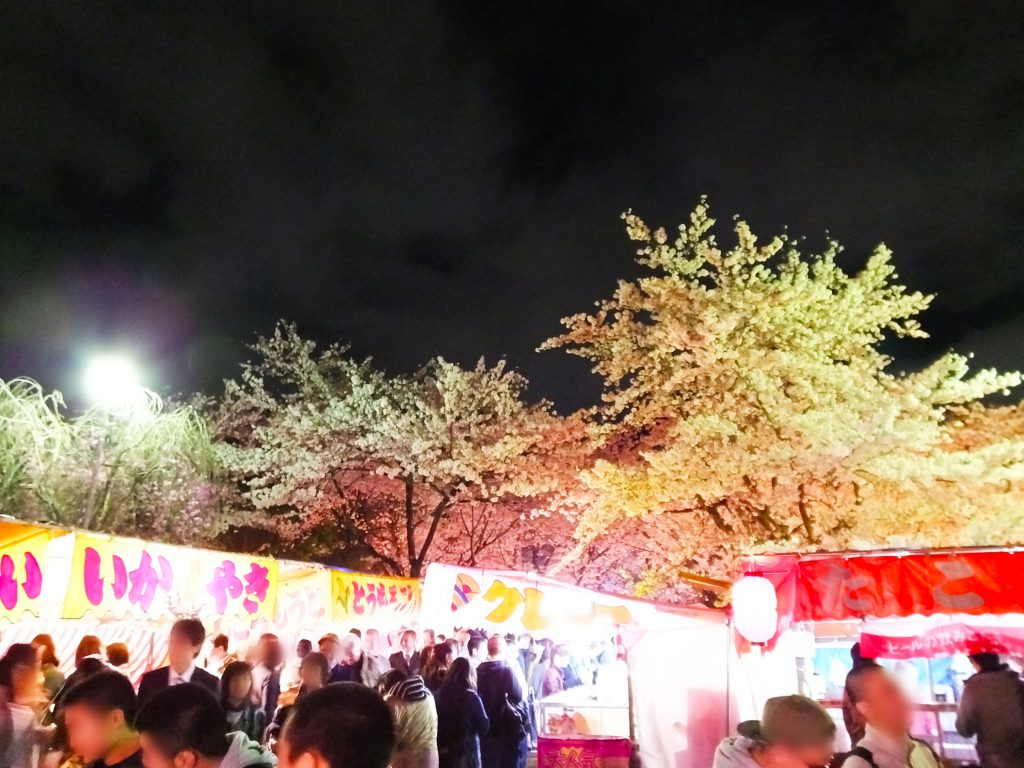 food stalls and lots of people under cherry trees