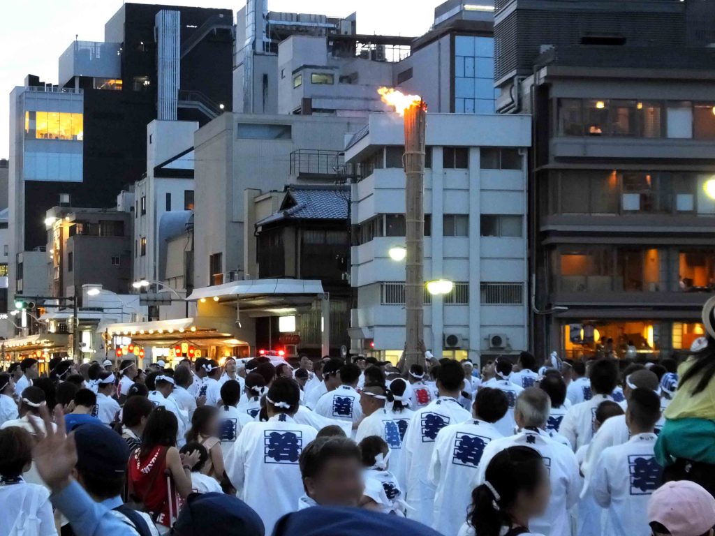 many people and the torch on the bridge